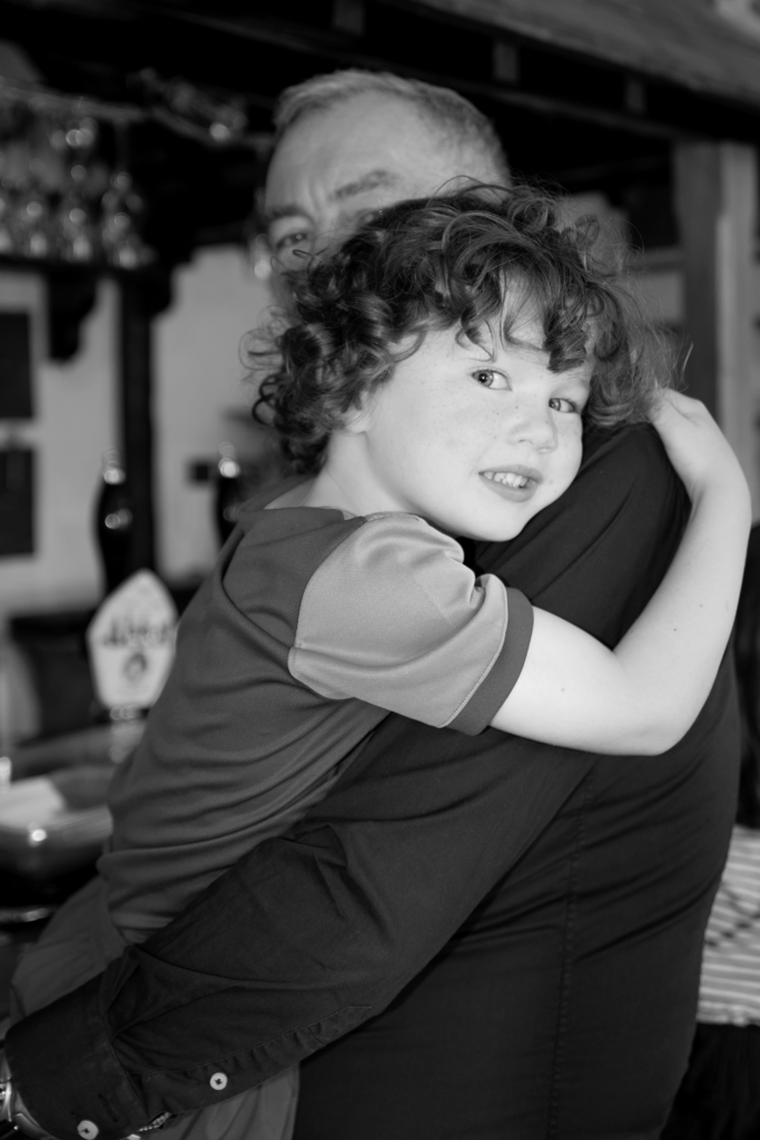 Photograph of a young boy being held by his Grandad